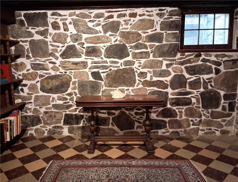 basement rumpus room with rubble stone walls and tile floor