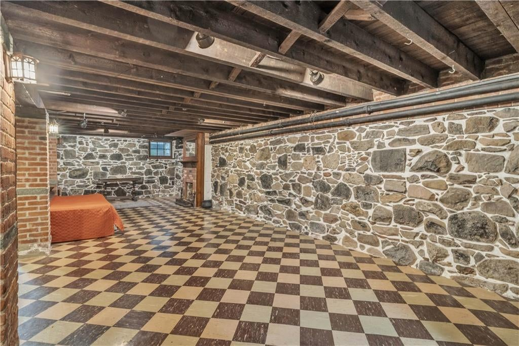 basement rumpus room with rubble stone walls and tile floor