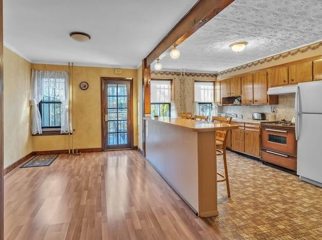 kitchen with linoleum floor, wood cabinets, open to dining