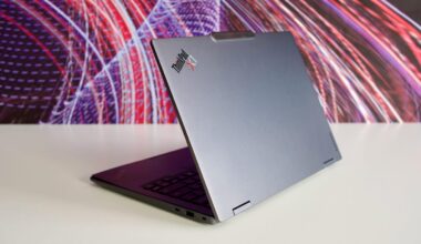 Lenovo ThinkPad X1 Carbon Gen 14 Aura Edition laptop sits on a table in front of a multicolored background.