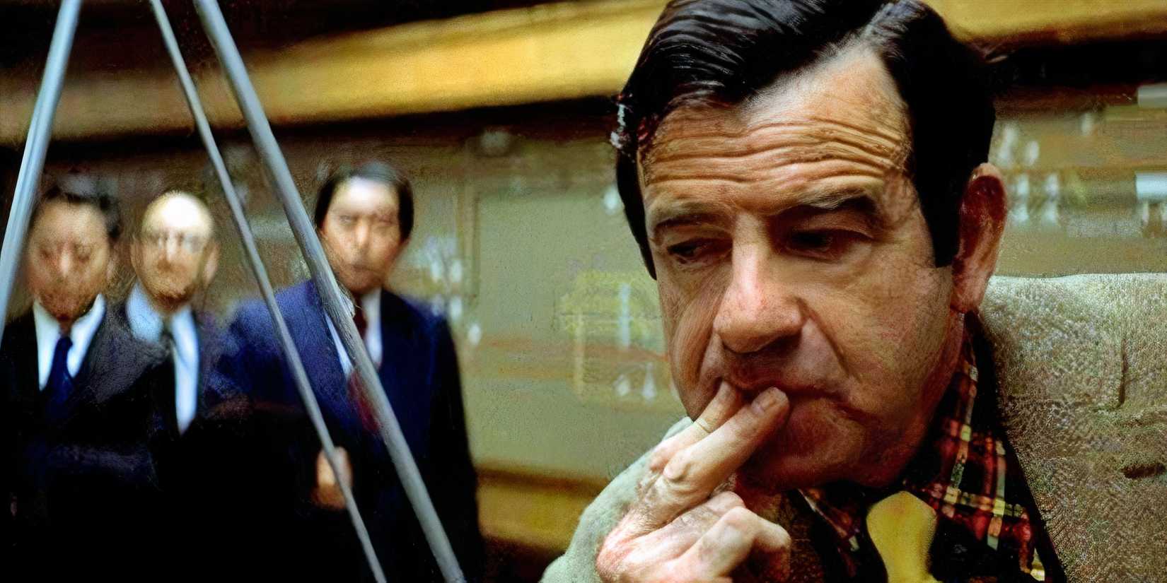 Walter Matthau resting his chin on his fingers while three men in suits standing the background in The Taking of Pelham One Two Three (1974)