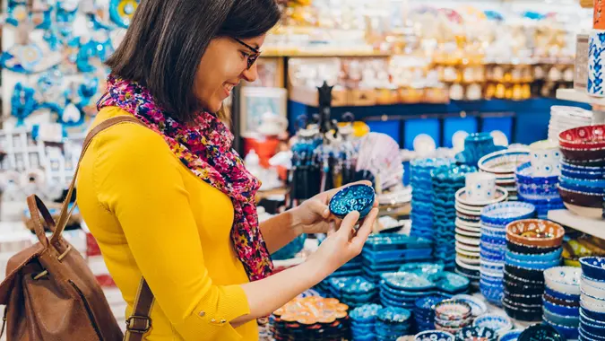 Woman dressed in bright colors, holding a small bowl, shopping in bazaar market, Istanbul stock photo