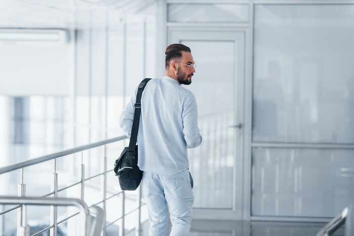 Man with bag walking away inside a hospital corridor, illustrating patients leaving the hospital against medical advice.