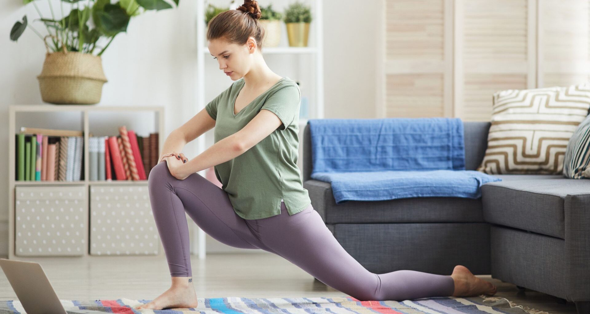 woman at home on yoga mat doing a hip flexor stretch