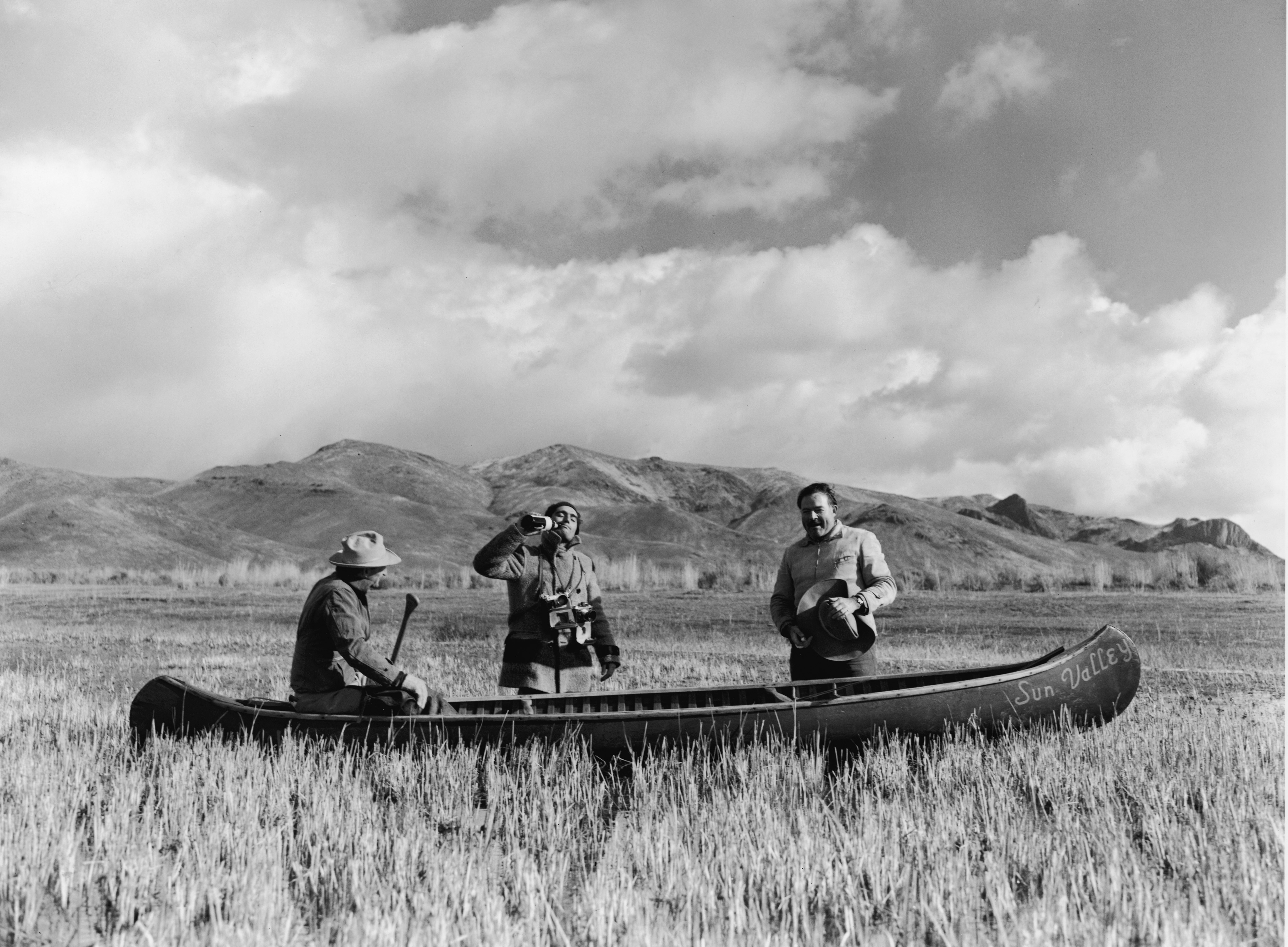 Guide Taylor Williams, photographer Robert Capa, and author Ernest Hemingway with a canoe on a duck hunt.