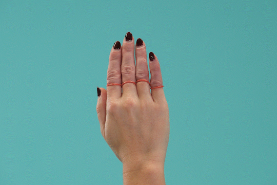 Animated GIF showing a hand with rubber bands around the base of each finger, performing finger abduction exercises.