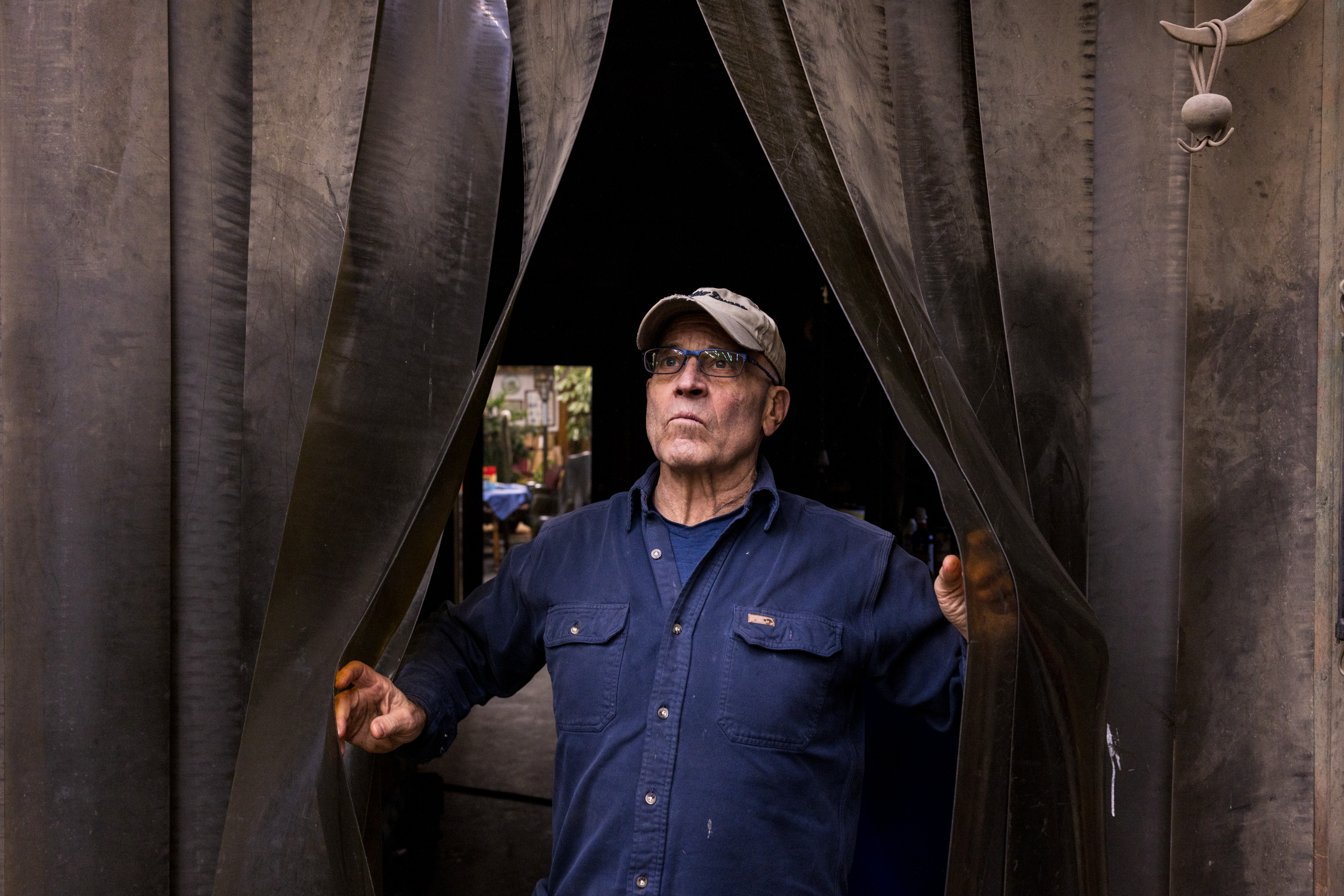 Alan Cottrill walks into the foundry, peering through heavy tarps.