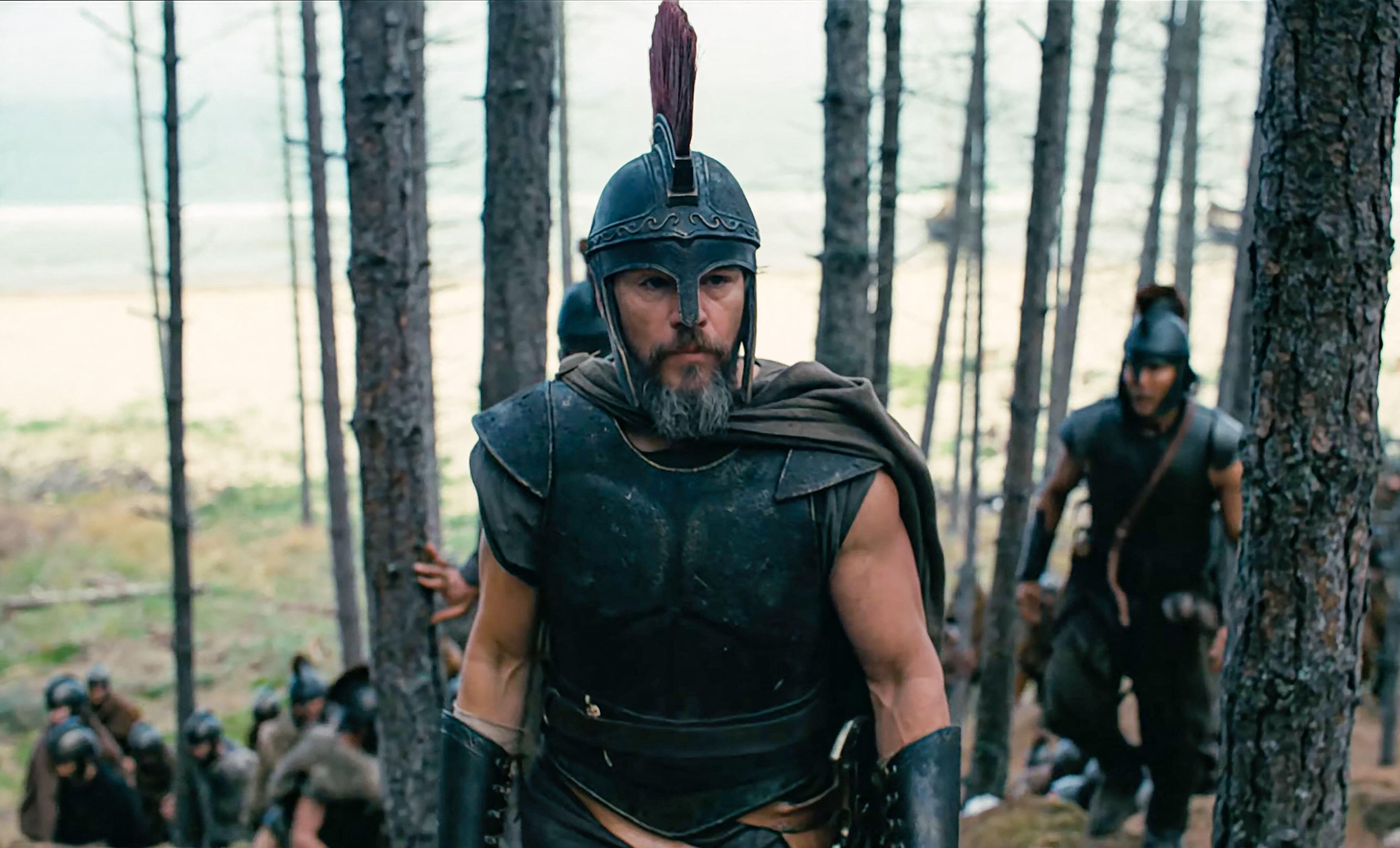 Matt Damon as Odysseus in full armor and helmet in a scene from "The Odyssey" (2026).