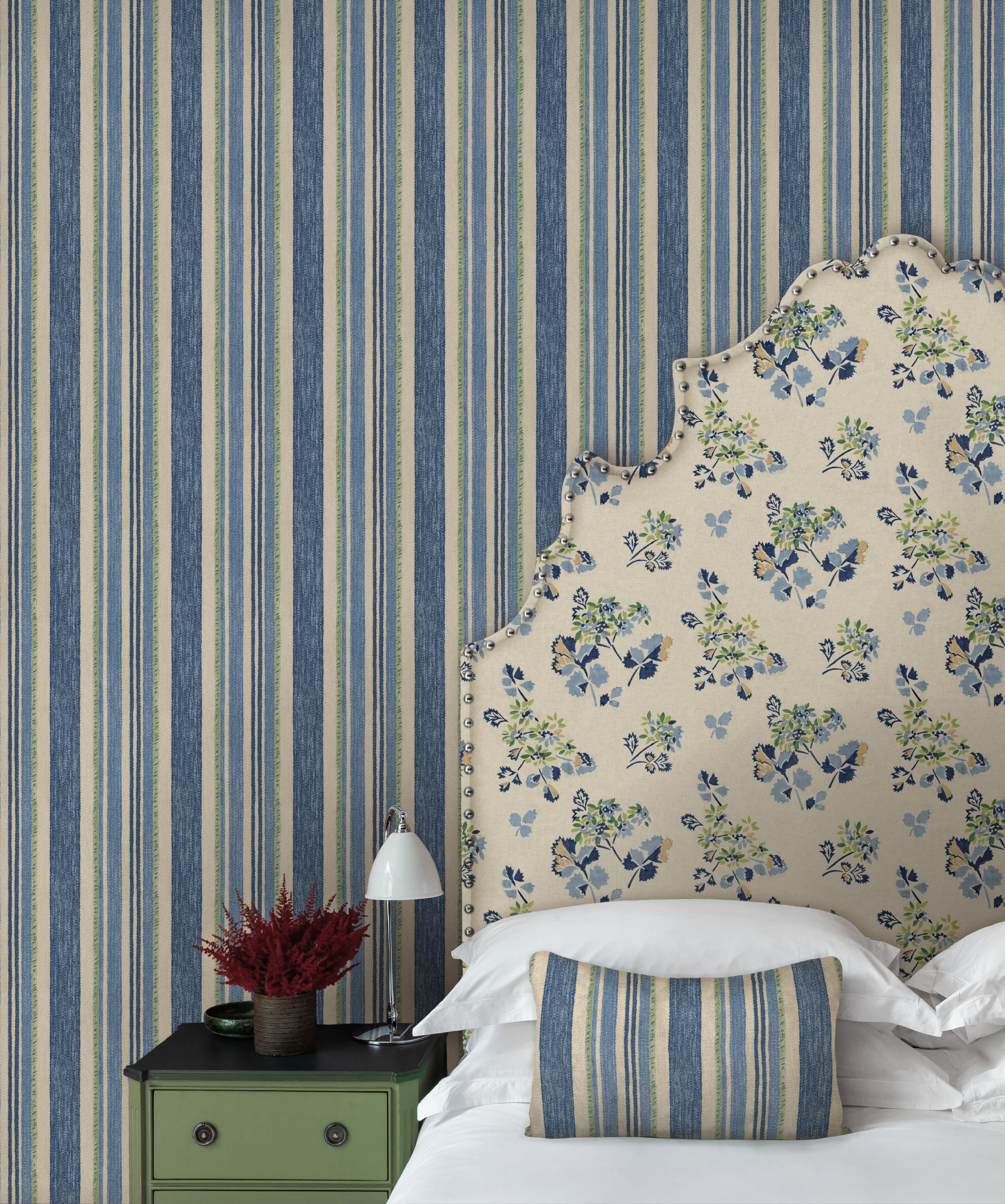 Bedroom with Cloudline striped wallpaper and floral headboard.