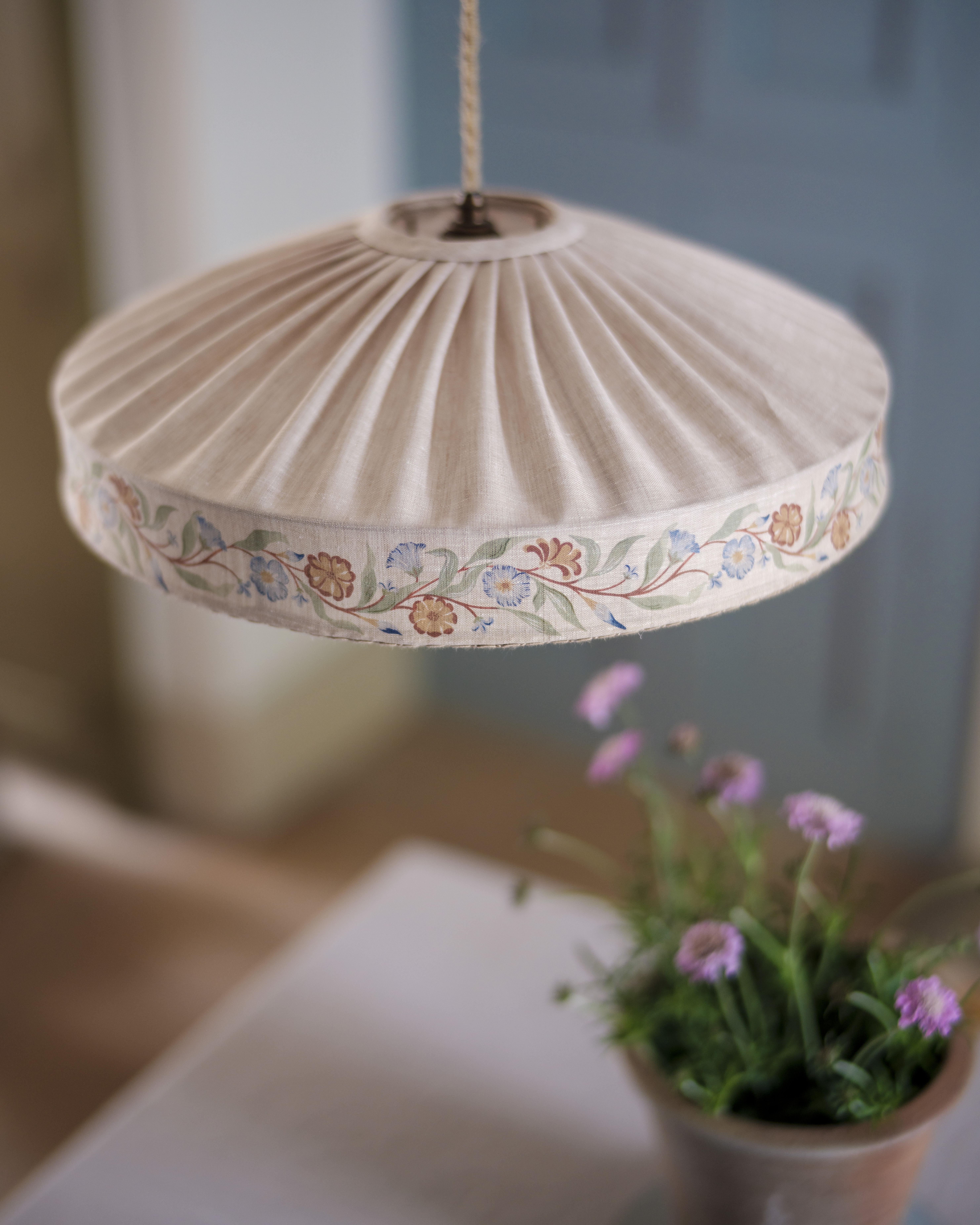 Pleated lampshade with floral embroidery.