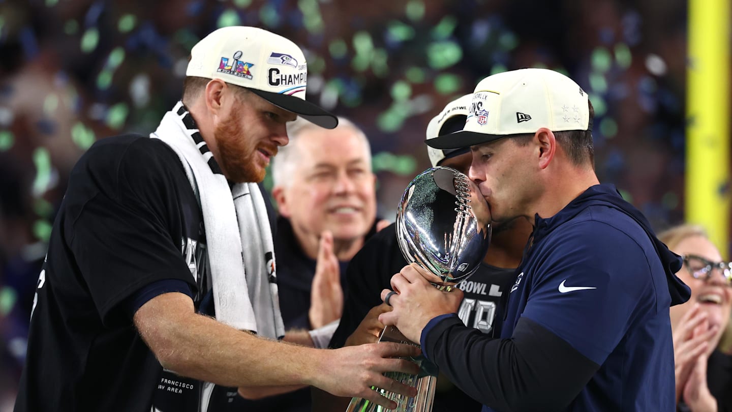 Feb 8, 2026; Santa Clara, CA, USA; Seattle Seahawks head coach Mike MacDonald and quarterback Sam Darnold (14) celebrate with the Vince Lombardi trophy on the podium after defeating the New England Patriots in Super Bowl LX at Levi's Stadium. Mandatory Credit: Mark J. Rebilas-Imagn Images