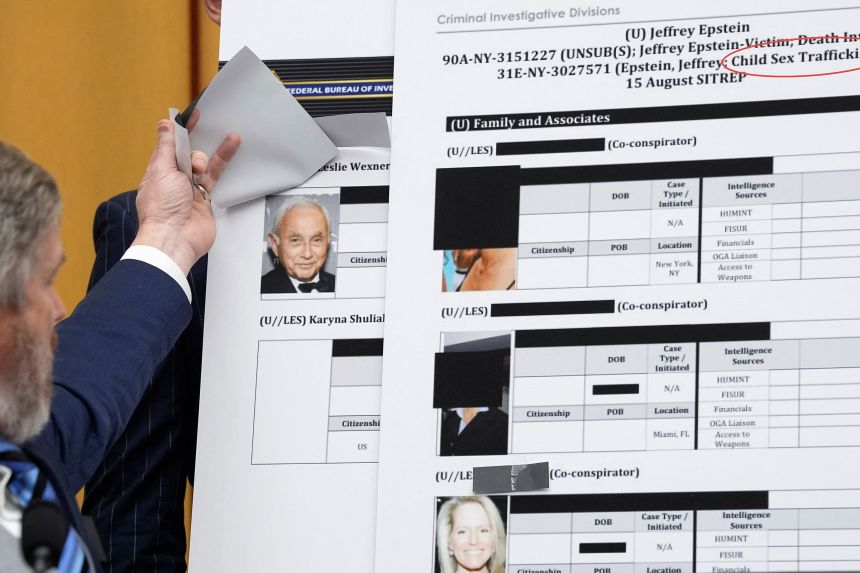 Rep. Thomas Massie lifts a piece of paper on a board displaying an FBI document, revealing an image of Les Wexner, during a House hearing on February 11.