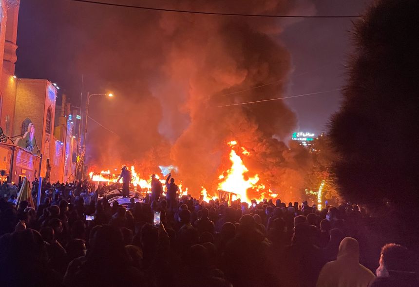 Iranian protesters gather around burning cars during a protest in Tehran on January 8, 2026.
