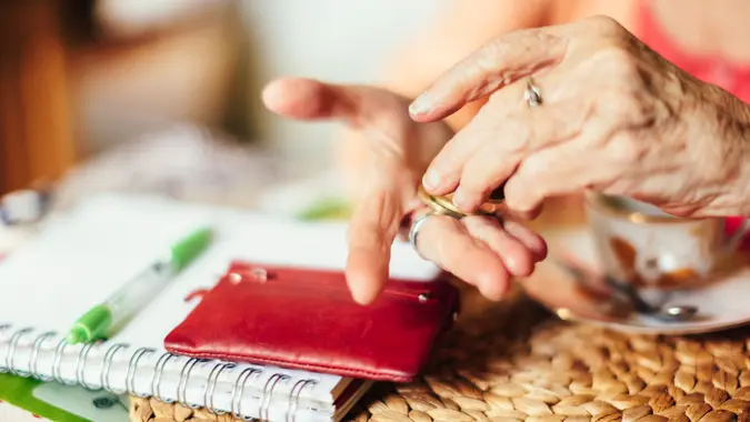Senior woman calculating finances in her kitchen.