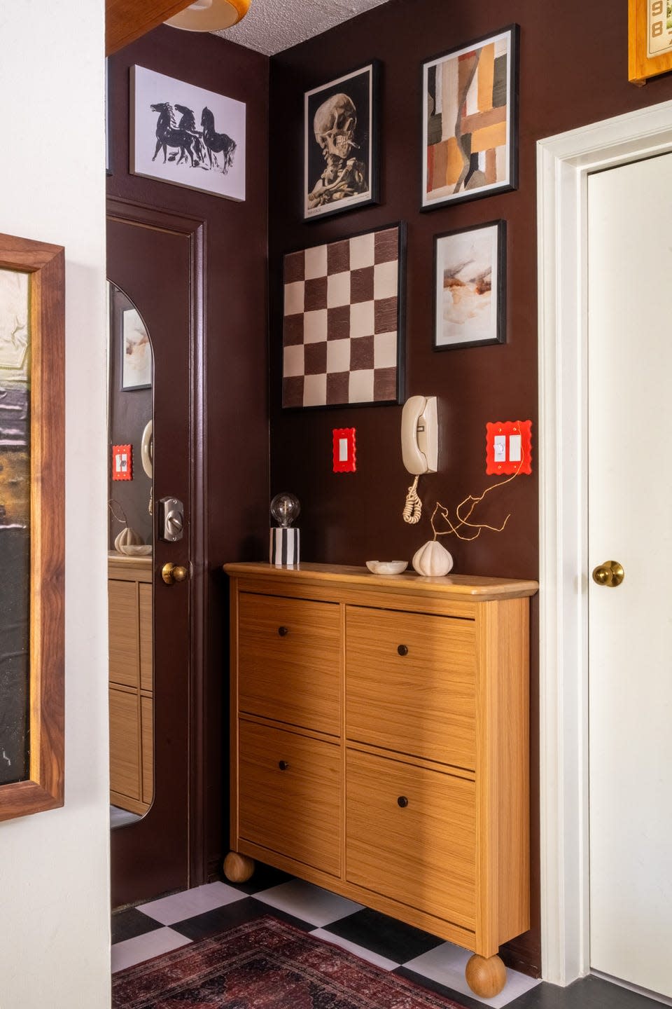 Entryway featuring brown walls and collection of framed artwork