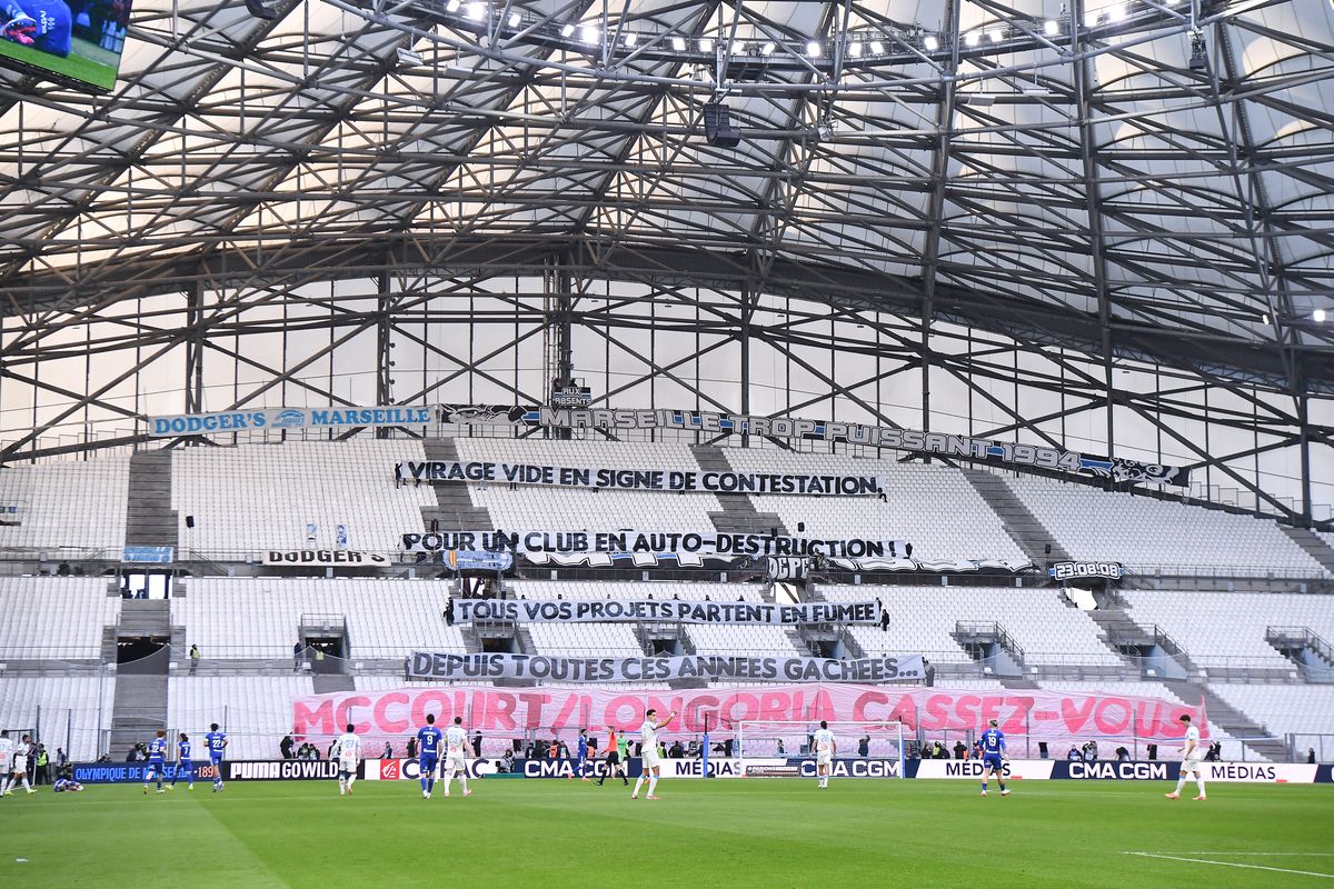 Fans of Marseille showing a banner saying "VIRAGE VIDE EN SIGNE DE CONTESTATION, POUR UN CLUB EN AUTO-DESTRUCTION, TOUS VOS PROJETS PARTENT EN FUMEE, DEPUIS TOUTES CES ANEES GACHEES" "MCCOURT/LONGORIA - CASSEZ-VOUS" during the Ligue 1 McDonald's match between Marseille and Strasbourg at Stade Velodrome on February 14, 2026 in Marseille, France. (Photo by Emilian Baldow/Icon Sport via Getty Images)