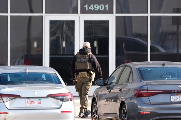 An ICE agent stands outside a warehouse as federal officials tour the facility to consider repurposing it as an ICE detention facility, Thursday, Jan. 15, 2026, in Kansas City, Mo. (AP Photo/Charlie Riedel)