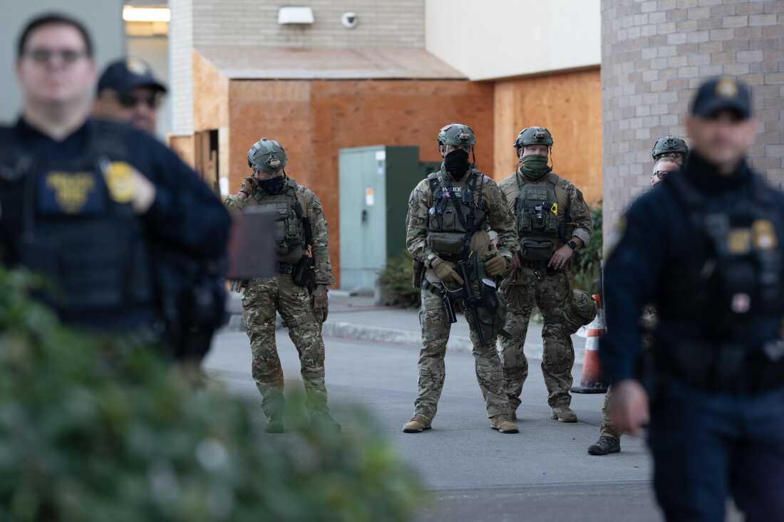 Law enforcement officers look out from a United States Immigration and Customs Enforcement (ICE) facility Oct. 21, 2025, in Portland, Ore.