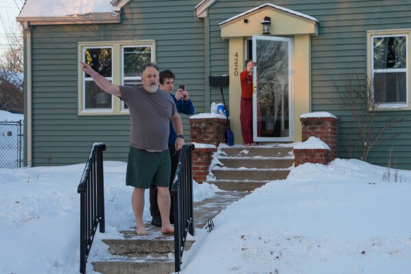 Residents film and yell at federal agents to leave their neighborhood while agents conduct immigration enforcement operations in a neighborhood in Minneapolis, Feb. 2, 2026. (AP Photo/Ryan Murphy, File)