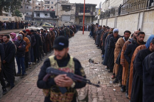 Former Syrian Democratic Forces members line up at a government-run reconciliation center to obtain official clearance documents stating they have left the group, a move aimed at avoiding further legal prosecution, in Raqqa, northeastern Syria, Feb. 1, 2026. (AP Photo/Ghaith Alsayed, File)