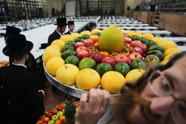 Ultra-Orthodox Jews from the Sanz Hasidic dynasty prepare a table with fruit to celebrate the Jewish holiday of Tu Bishvat, or the "New Year of the Trees," in Netanya, Israel, Feb. 2, 2026. (AP Photo/Ariel Schalit, File)