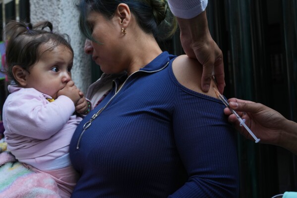 A health worker administers a dose of the measles vaccine outside a public hospital in Mexico City, Wednesday, Feb. 4, 2026. (AP Photo/Marco Ugarte)
