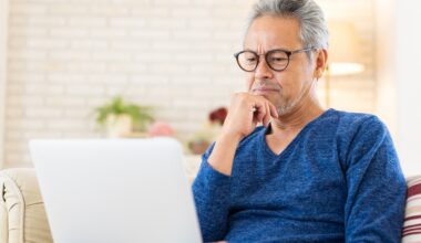 Elderly man using laptop, think, stock photo