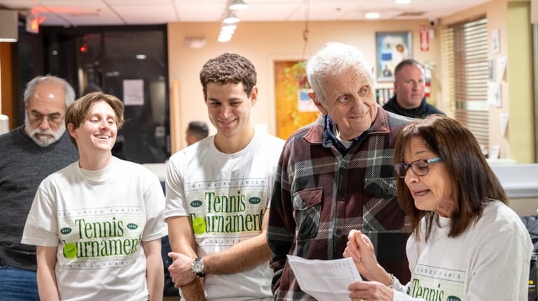 Tournament founder Stephen Green, 89, in plaid shirt, listens with...