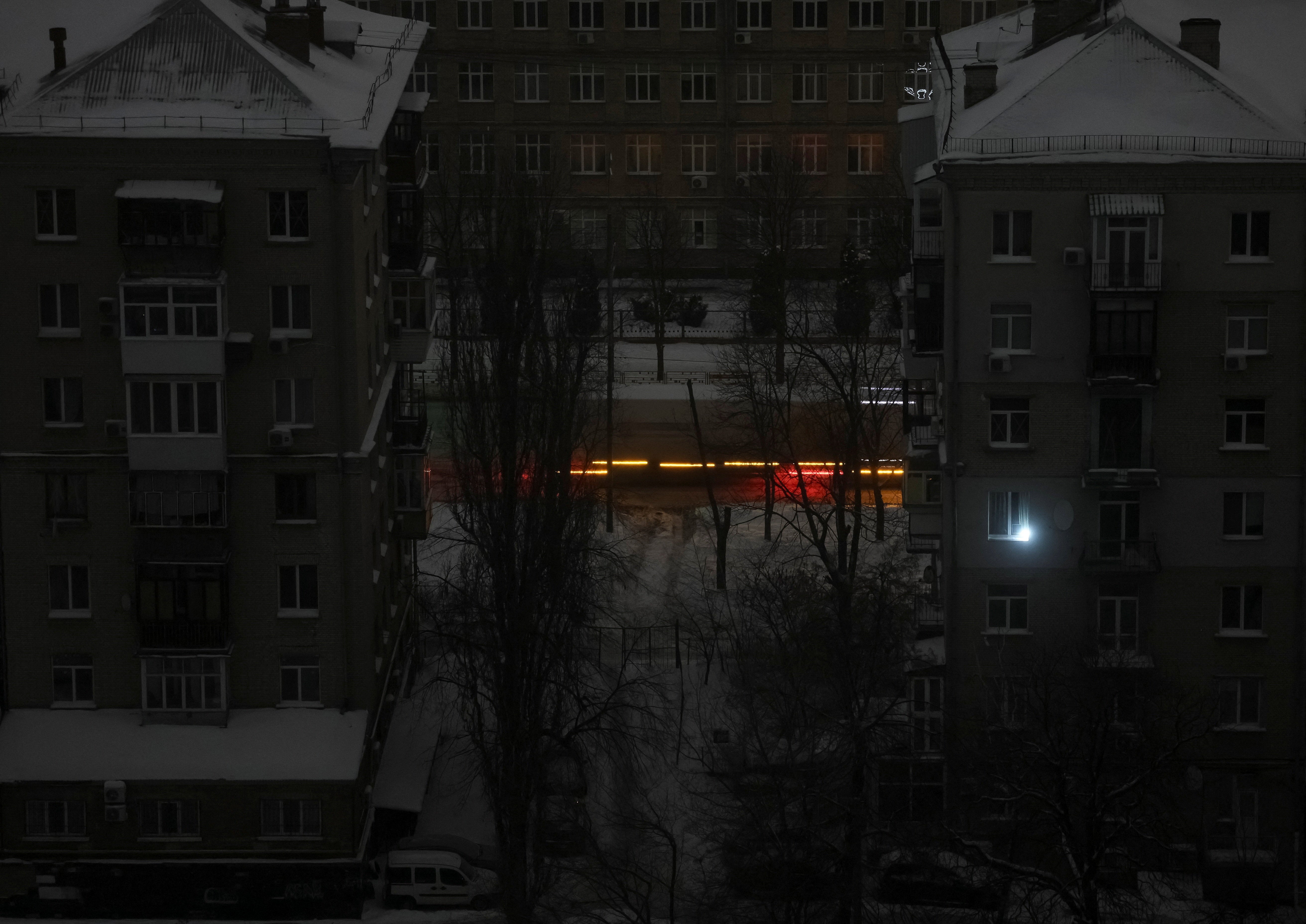 A car drives on a street during a power blackout after critical civil infrastructure was hit by night's Russian missile and drone attacks, amid Russia's attack on Ukraine, in Kyiv, Ukraine February 7, 2026