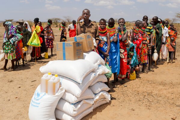 Locals queue to receive food aid as severe drought continues, in Nalemkais Village, Turkana County, Kenya, Sunday, Feb. 8, 2026. (AP Photo/Patrick Ngugi)