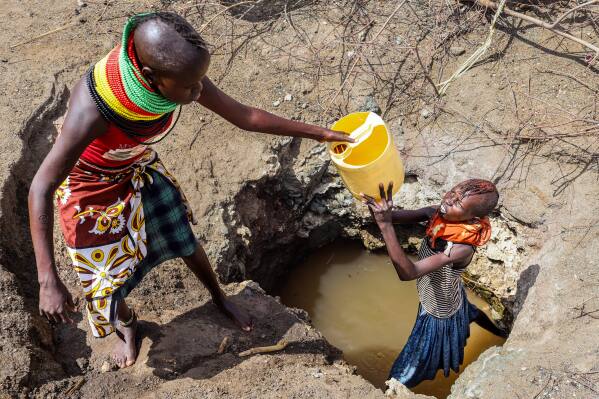 Turkana women fetch water from a well in Lopii Village, Turkana County, Kenya, Monday, Feb. 9, 2026. (AP Photo/Patrick Ngugi)