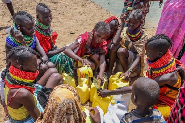 Locals share food rations distributed by World Vision Kenya as severe drought continues, in Nalemkais Village, Turkana County, Kenya, Sunday, Feb. 8, 2026. (AP Photo/Patrick Ngugi)