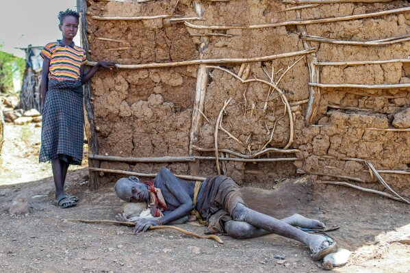 Achukwa Lotukoi Nakine, 87, lies beside his grandson amid a prolonged drought in Nadunga Village, Turkana County, Kenya, Friday, Feb. 6, 2026. (AP Photo/Patrick Ngugi)