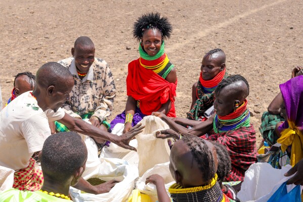 Locals share food rations distributed by World Vision Kenya as severe drought continues, in Nalemkais Village, Turkana County, Kenya, Sunday, Feb. 8, 2026. (AP Photo/Patrick Ngugi)