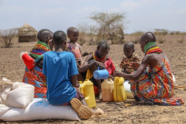 Locals share food rations distributed by World Vision Kenya as severe drought continues, in Nalemkais Village, Turkana County, Kenya, Sunday, Feb. 8, 2026. (AP Photo/Patrick Ngugi)