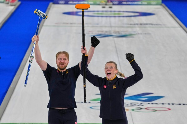 Sweden's Rasmus Wranaa and Isabella Wranaa celebrate after winning the gold medal mixed doubles curling match against USA, at the 2026 Winter Olympics, in Cortina D'Ampezzo, Italy, Tuesday, Feb. 10, 2026. (AP Photo/Misper Apawu)