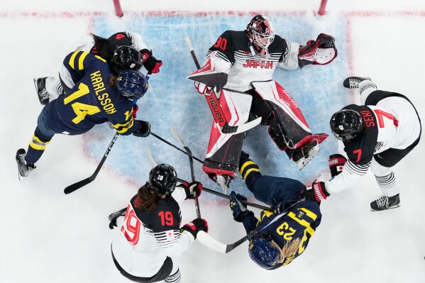 Japan's Rei Halloran makes a save during a preliminary round match of women's ice hockey between Japan and Sweden at the 2026 Winter Olympics, in Milan, Italy, Tuesday, Feb. 10, 2026. (AP Photo/Petr David Josek)