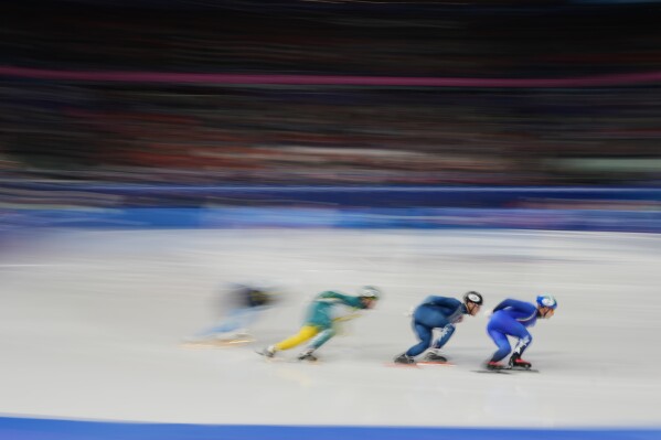 Pietro Sighel of Italy, right, leads his heat while competing in the men's 1000 meter short track speed skating at the 2026 Winter Olympics, in Milan, Italy, Tuesday, Feb. 10, 2026. (AP Photo/Francisco Seco)
