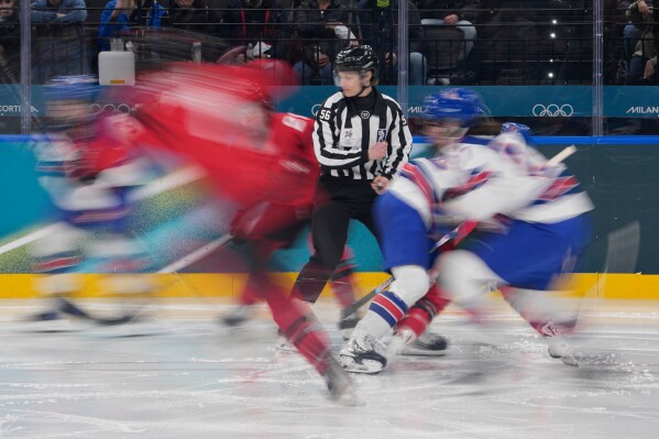 Line judge Sarah Buckner stands as players run during a preliminary round match of women's ice hockey between the United States and Canada at the 2026 Winter Olympics, in Milan, Italy, Tuesday, Feb. 10, 2026. (AP Photo/Petr David Josek)