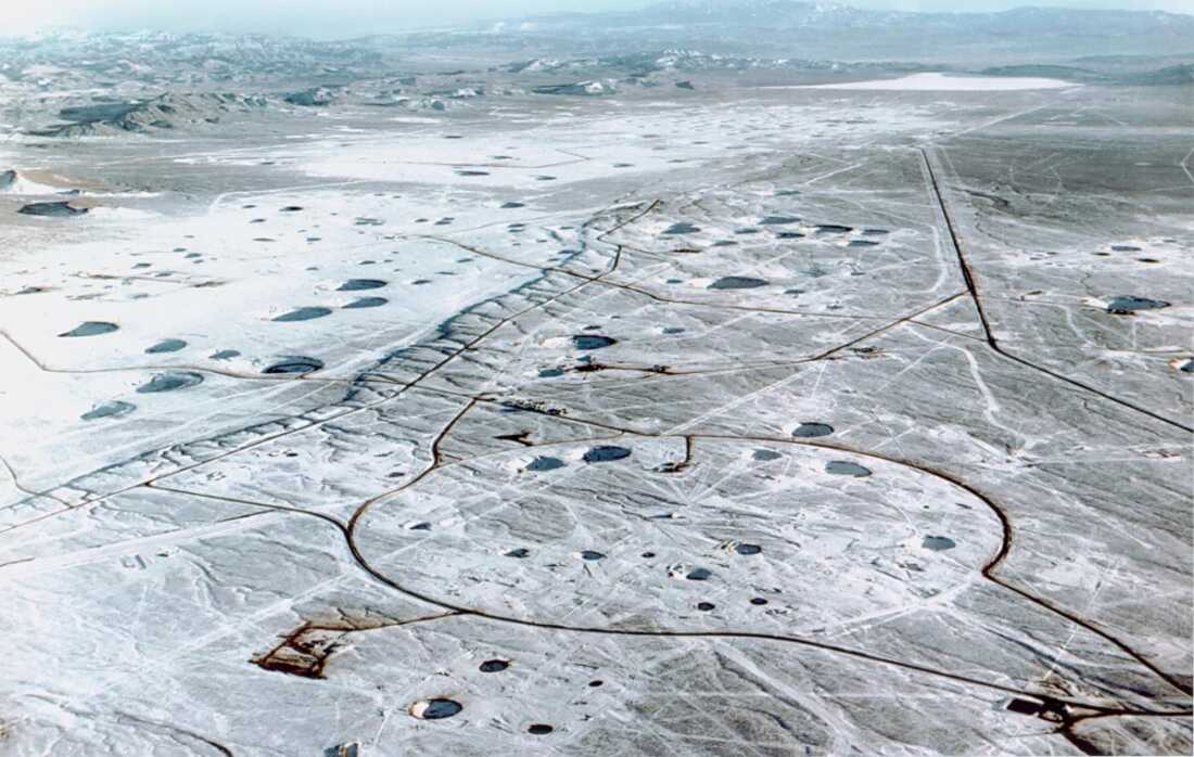 This aerial photo of an area in Nevada shows many round subsidence craters on the land surface that were created by massive underground explosions during U.S. testing.
