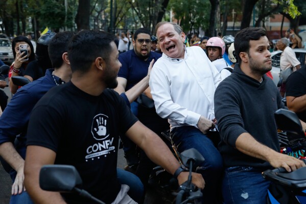 Opposition leader Juan Pablo Guanipa rides on the back of a motorcycle after his release from prison in Caracas, Venezuela, Feb. 8, 2026. (AP Photo/Cristian Hernandez, File)