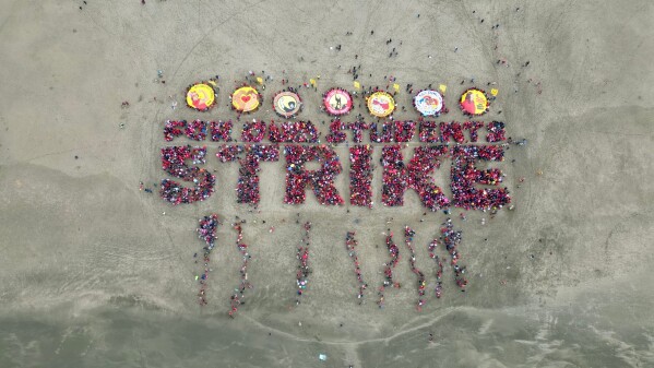 San Francisco teachers form a human banner spelling "STRIKE" on Ocean Beach on the third day of a district-wide strike over wages, benefits and other issues, Feb. 11, 2026. (AP Photo/Terry Chea, File)