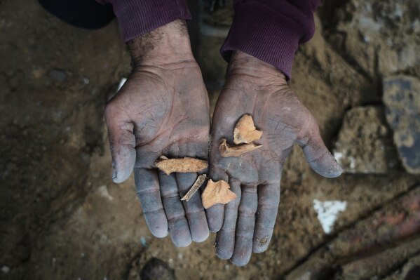 Fragments of bone are shown to the camera during a search for the remains of Nema Hammad, who is buried beneath the rubble of her home that was destroyed by an Israeli airstrike in December 2023, in Gaza City, Feb. 9, 2026. (AP Photo/Jehad Alshrafi, File)