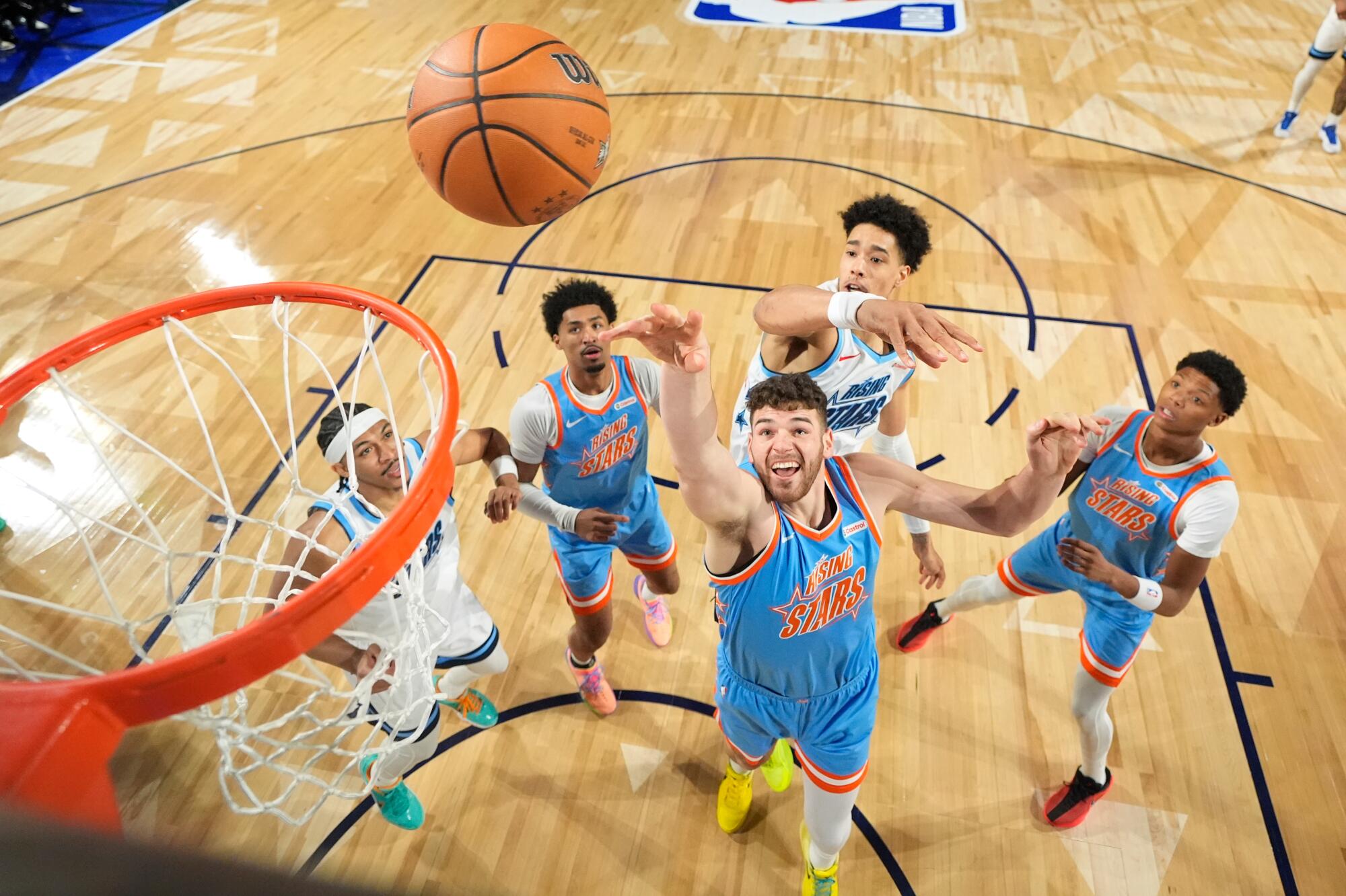 Team Melo frontcourt Donovan Clingan reaches for a rebound along with Team Austin's Yanic Konan Niederhauser.