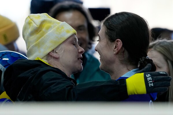 Belgium's Kim Meylemans, left, and Brazil's Nicole Rocha Silveira react, at the finish during a women's skeleton run at the 2026 Winter Olympics, in Cortina d'Ampezzo, Italy, Friday, Feb. 13, 2026. (AP Photo/Alessandra Tarantino)