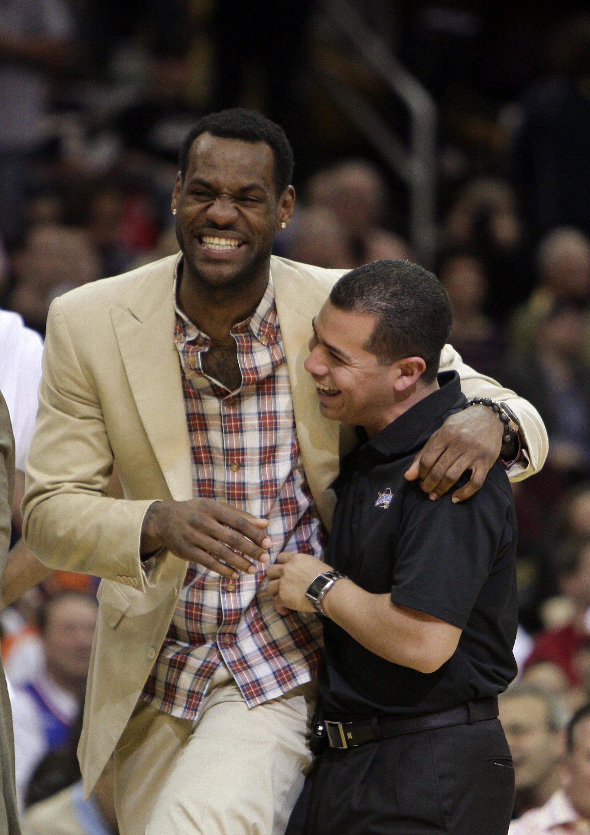 LeBron James, left, jokes with trainer Mike Mancias, right, while sitting out a game with the Cavaliers in 2010.