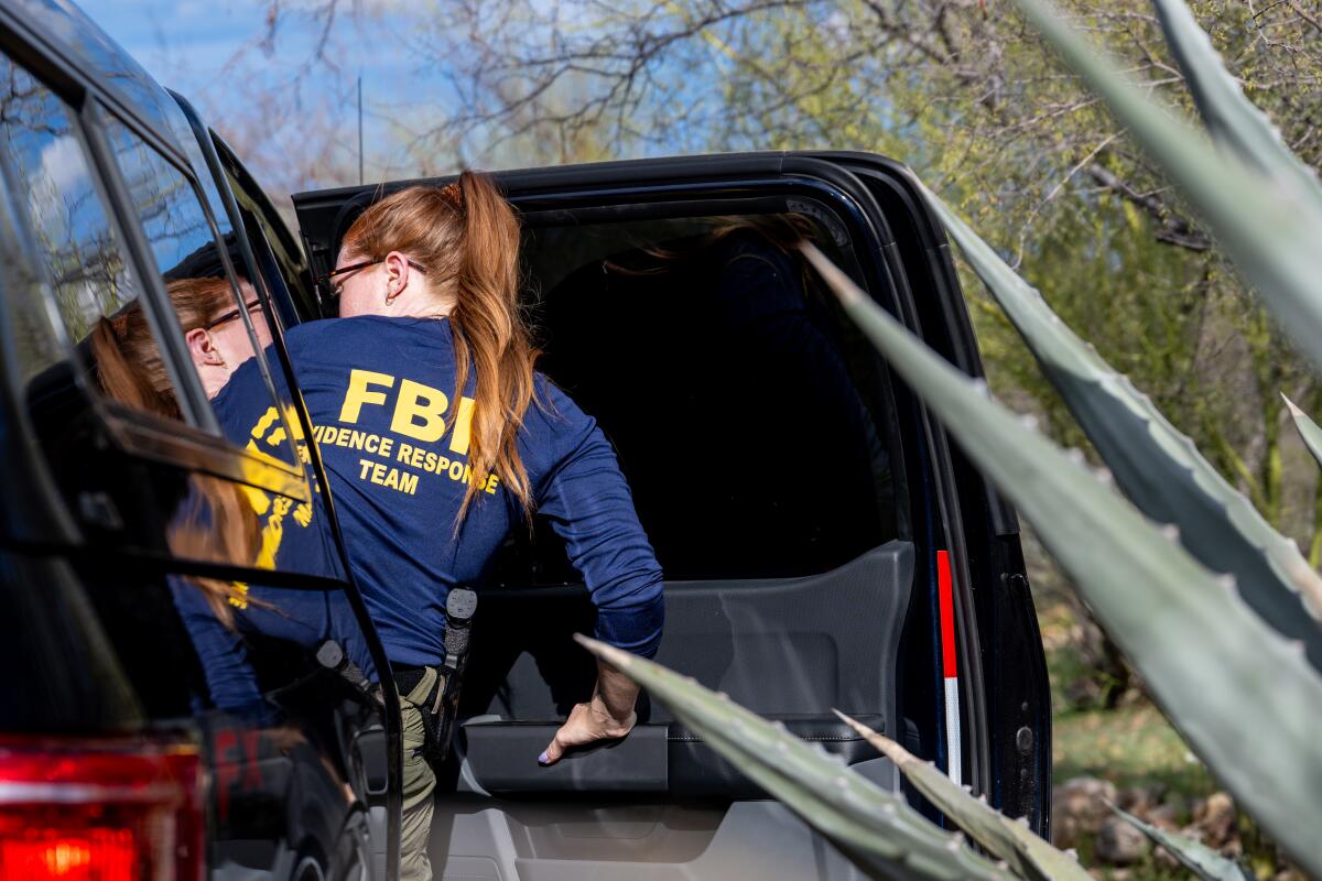 A member of the FBI departs from the entrance of Nancy Guthrie's residence