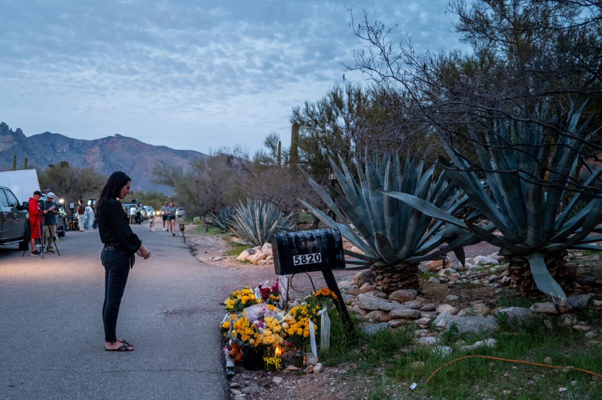 a person pays their respects to a makeshift memorial