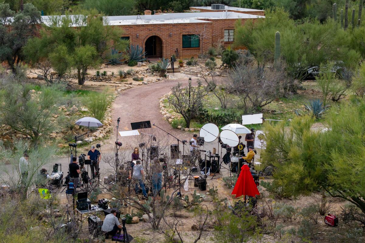 In an aerial view, news broadcasters are stationed outside Nancy Guthrie's residence