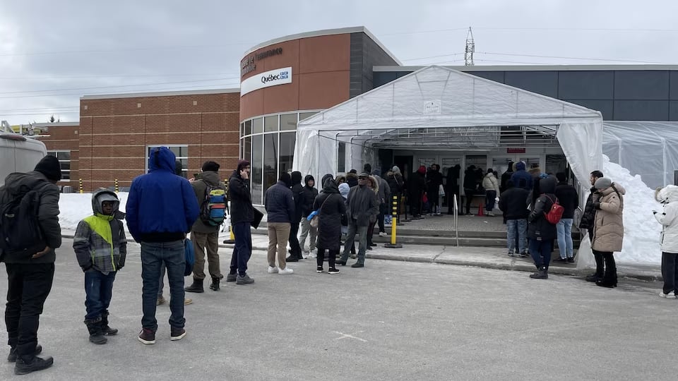 People line up outside a SAAQ branch in winter. 